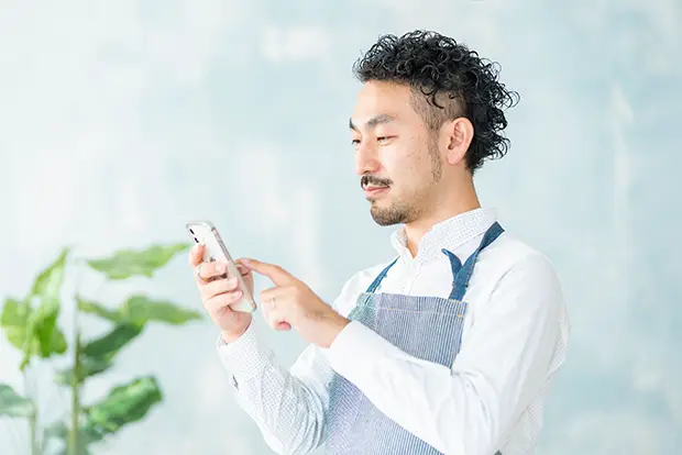 スマホを見る店員